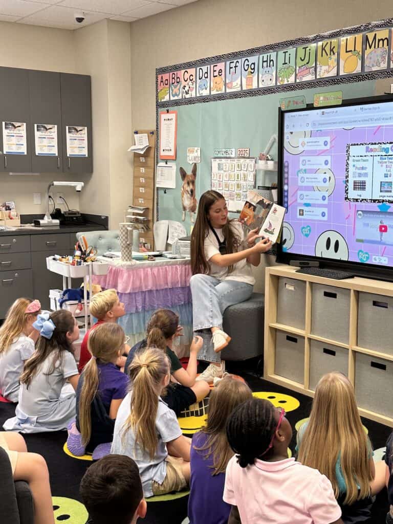 Grupa uczniów ogląda zdjęcia na ekranie laptopa w szkolnej pracowni