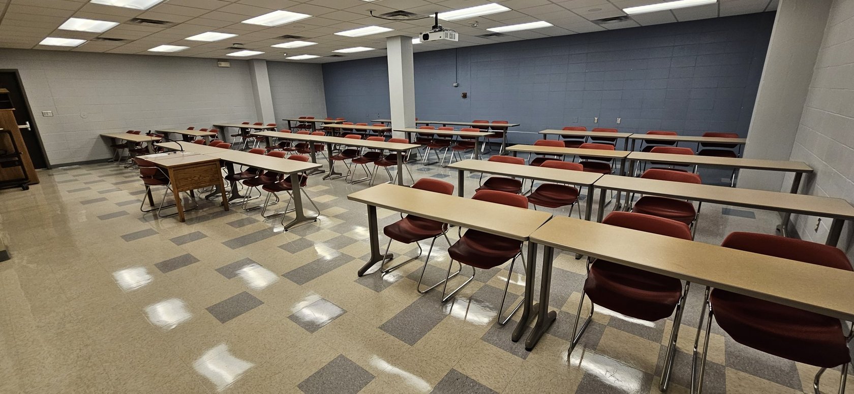 Uczeń poprawia kompozycję zdjęcia kwiatów na stole w klasie szkolnej