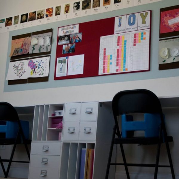 grupa uczniów w klasie klei kolorowe kartki i rysunki do tablicy