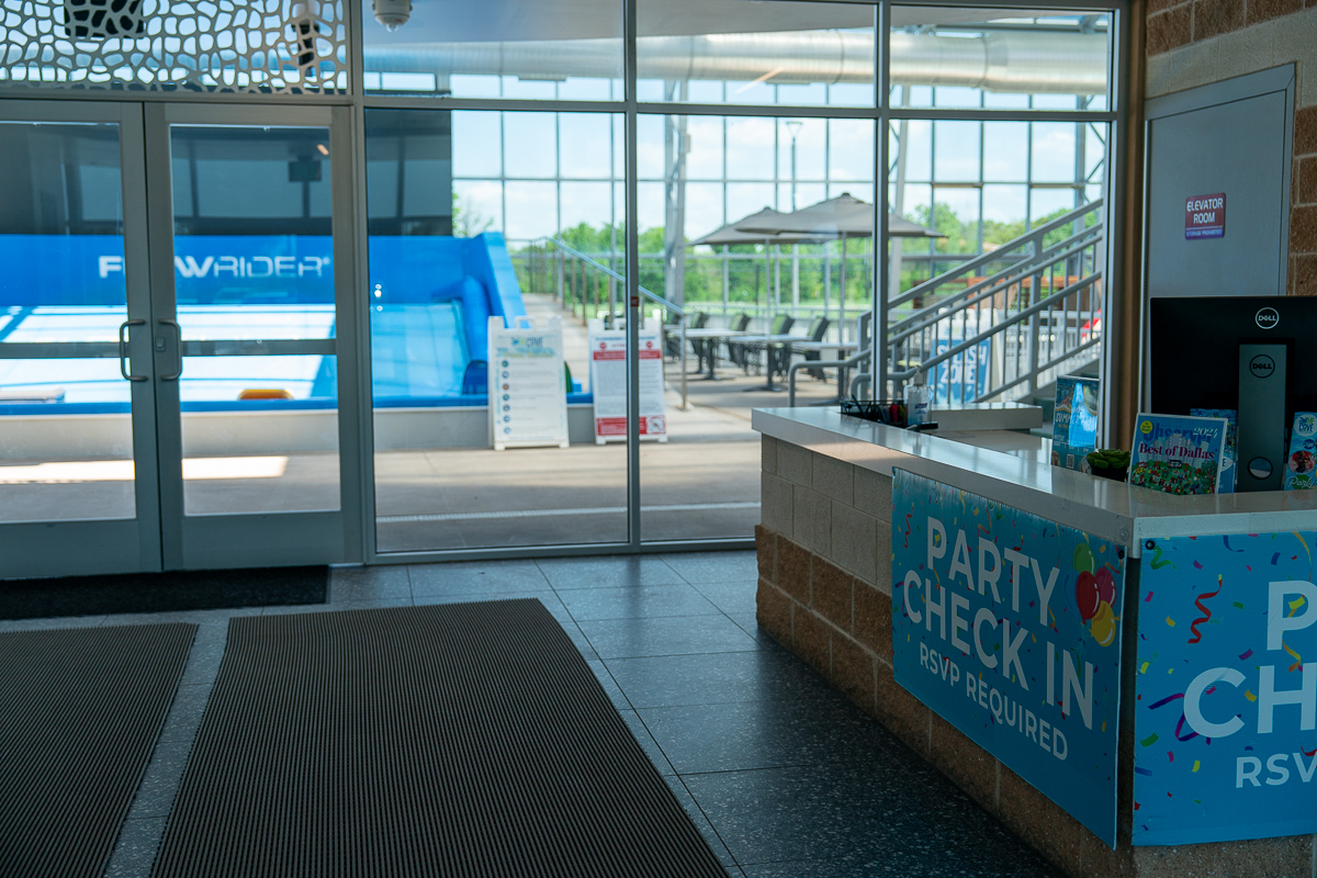 szkolny autobus zaparkowany przed wejściem do szkoły z uczniami obok