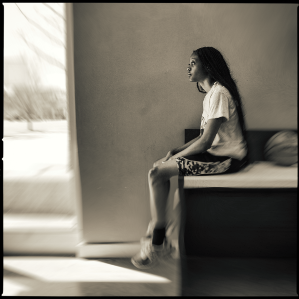 Uczniowie w klasie stoją przy tablicy z powieszonymi zdjęciami podczas konkursu fotograficznego